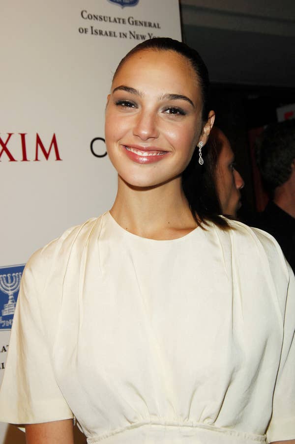 Gal Gadot wearing a white top posing at an event in the early 2000s